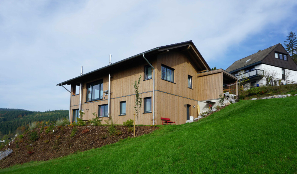 Стильный дизайн: двухэтажный, деревянный, коричневый частный загородный дом в стиле кантри с двускатной крышей - последний тренд