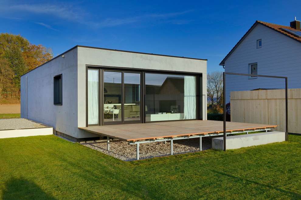 Immagine della facciata di una casa grigia moderna a due piani di medie dimensioni con rivestimento in cemento e tetto piano