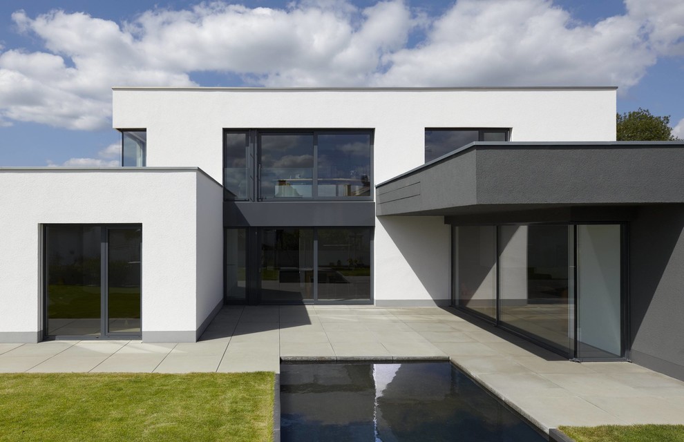 На фото: двухэтажный, белый дом среднего размера в стиле модернизм с плоской крышей с