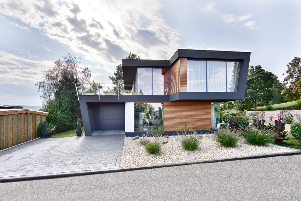 Inspiration pour une façade de maison noire design à un étage et de taille moyenne avec un revêtement mixte et un toit plat.