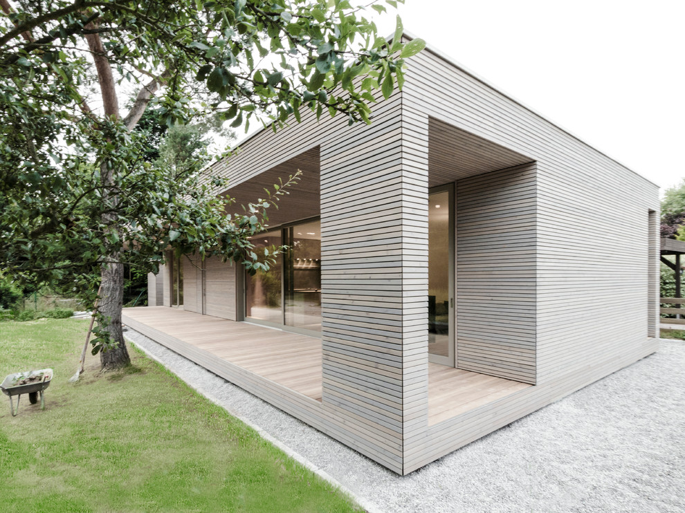 Modern bungalow house exterior in Berlin with wood cladding and a flat roof.