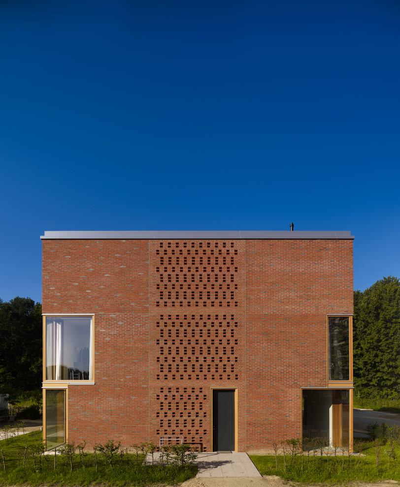 Mittelgroßes, Dreistöckiges Modernes Haus mit Backsteinfassade, roter Fassadenfarbe und Flachdach in Bremen