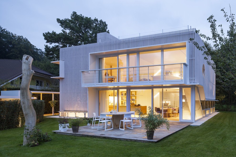 Esempio della facciata di una casa grande bianca contemporanea a due piani con tetto piano e rivestimento in legno