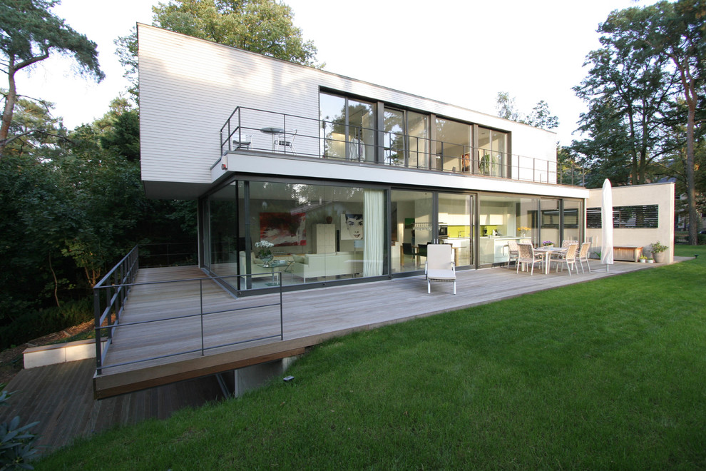 Cette image montre une façade de maison blanche minimaliste à un étage et de taille moyenne avec un toit plat.