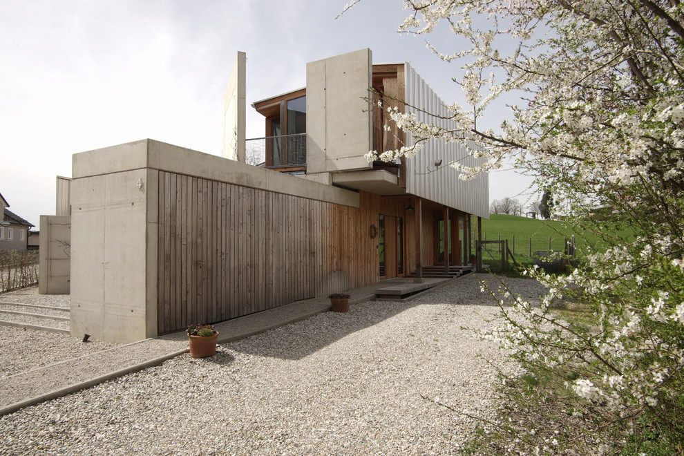 Diseño de fachada marrón contemporánea de tamaño medio a niveles con revestimiento de madera y tejado a dos aguas