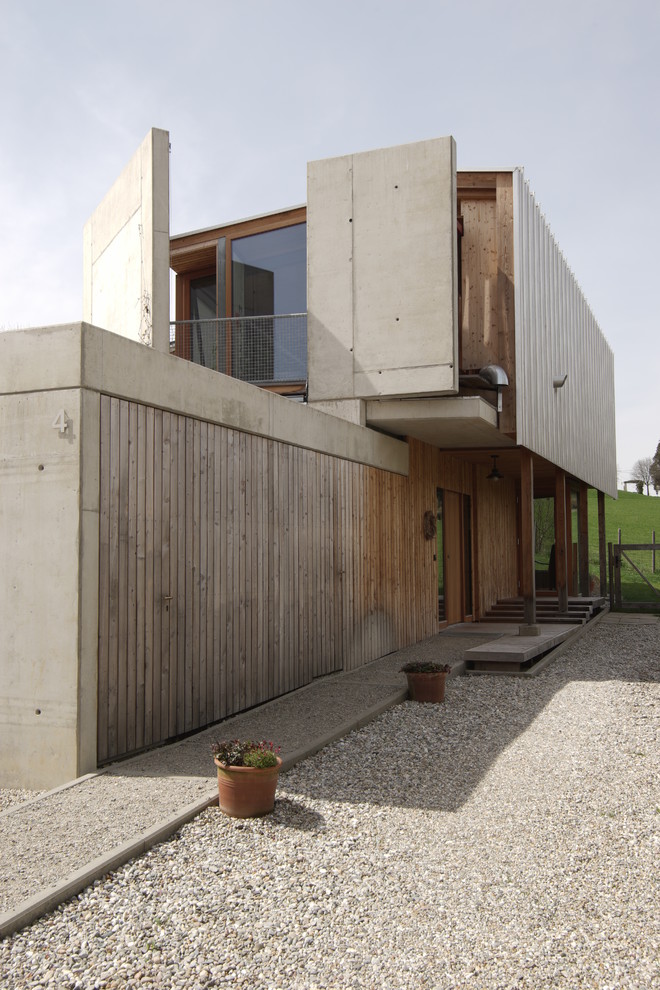 Cette photo montre une façade de maison marron moderne en bois de taille moyenne et à niveaux décalés avec un toit à deux pans.