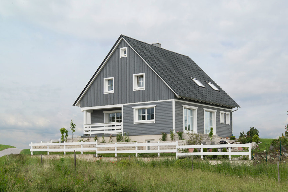Modelo de fachada gris escandinava de dos plantas con revestimiento de madera y tejado a dos aguas