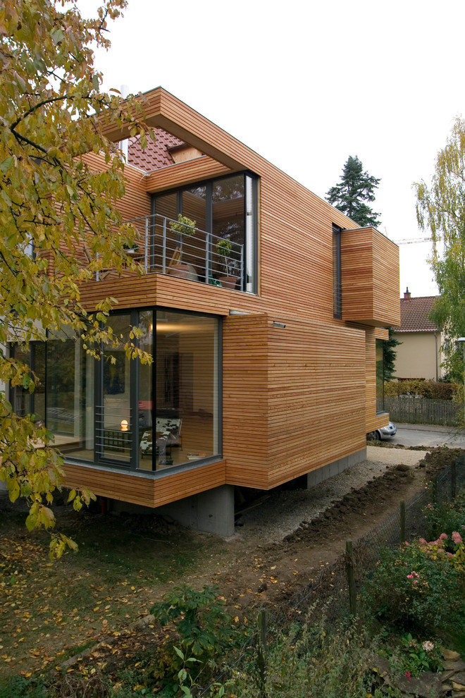 Foto della facciata di una casa marrone contemporanea a due piani di medie dimensioni con rivestimento in legno e tetto piano