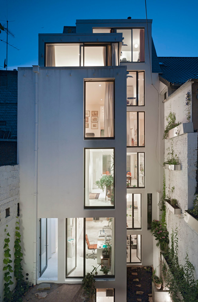 Réalisation d'une façade de maison blanche design de taille moyenne et à deux étages et plus avec un toit plat.