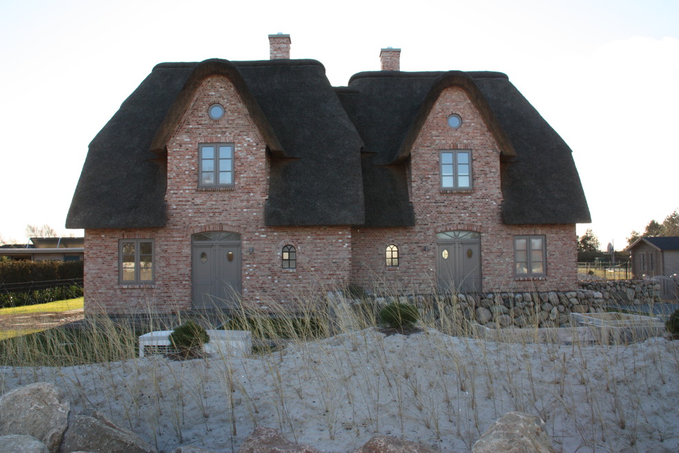Ispirazione per la facciata di una casa bifamiliare bianca rustica di medie dimensioni con rivestimento in mattoni