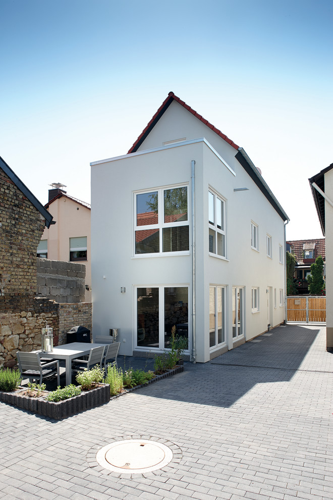 Dreistöckiges Modernes Einfamilienhaus mit Putzfassade, grauer Fassadenfarbe, Satteldach und Ziegeldach in Sonstige