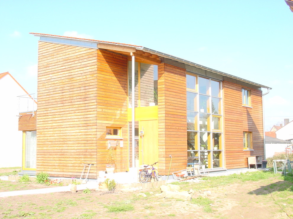 Foto de fachada de casa marrón industrial de tamaño medio de dos plantas con revestimiento de madera, tejado de un solo tendido y tejado de teja de barro
