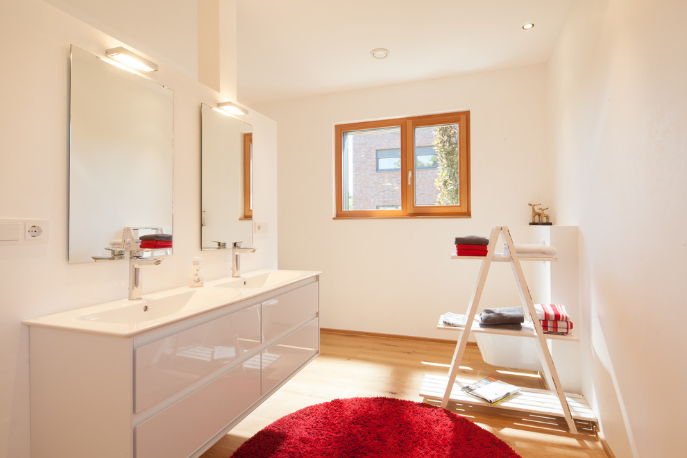 Foto di un'ampia stanza da bagno moderna con ante lisce, parquet chiaro, due lavabi e mobile bagno sospeso