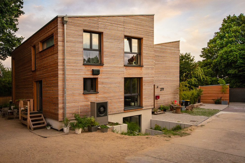 Inspiration pour une très grande façade de maison mitoyenne marron minimaliste en bois et bardage à clin à un étage avec un toit en appentis.