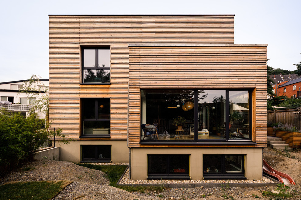 Geräumiges, Zweistöckiges Modernes Haus mit brauner Fassadenfarbe, Pultdach und Verschalung in Düsseldorf