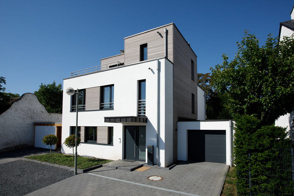 Geräumiges, Dreistöckiges Modernes Einfamilienhaus mit weißer Fassadenfarbe, Flachdach, Mix-Fassade und Verschalung in Düsseldorf