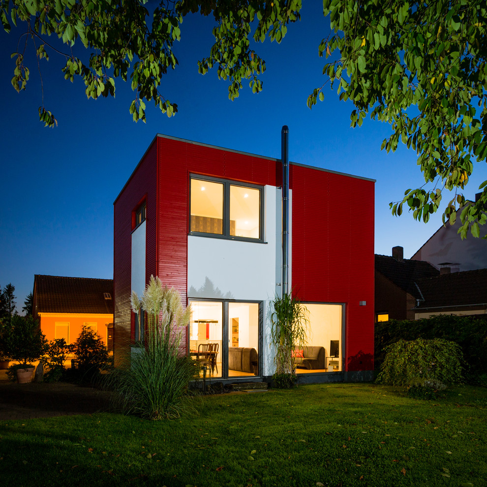 Geräumiges, Zweistöckiges Modernes Haus mit Flachdach, roter Fassadenfarbe und Verschalung in Sonstige