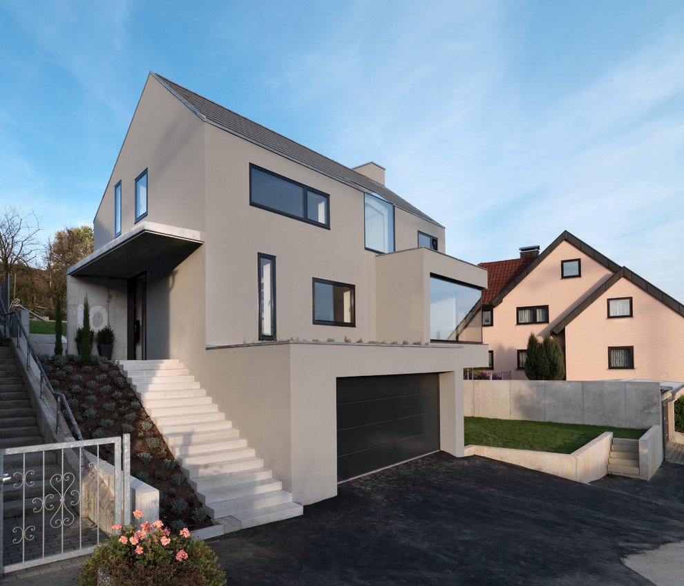 Large contemporary gray three-story gable roof idea in Stuttgart