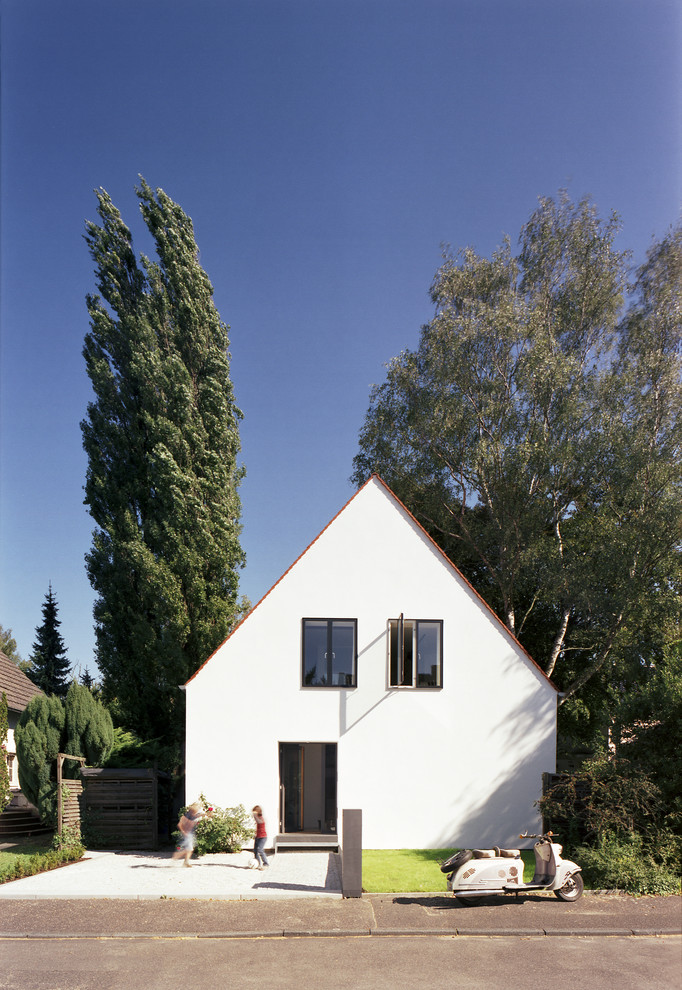Idées déco pour une façade de maison blanche contemporaine en stuc de taille moyenne et à un étage avec un toit à deux pans.