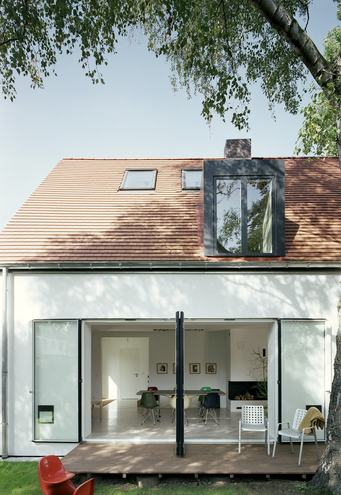 Aménagement d'une façade de maison blanche contemporaine à un étage avec un toit à deux pans.