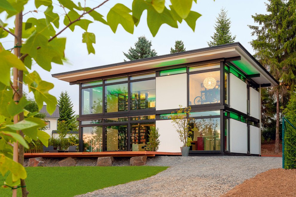 Imagen de fachada de casa actual extra grande de dos plantas con revestimientos combinados, tejado plano y tejado de varios materiales