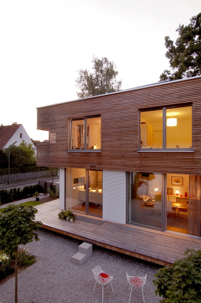Cette photo montre une façade de maison tendance en bois de taille moyenne et à un étage avec un toit plat.