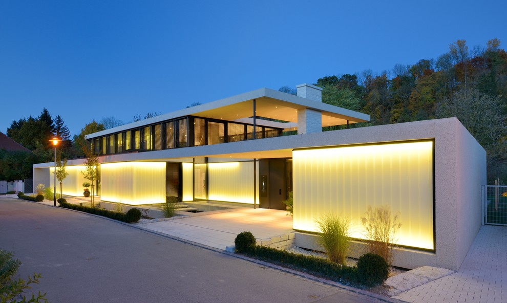 Large and gey contemporary two floor house exterior in Munich with concrete fibreboard cladding and a flat roof.