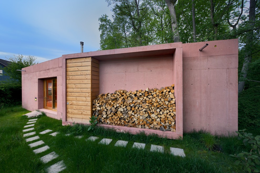Идея дизайна: одноэтажный, маленький, розовый дом в современном стиле с облицовкой из бетона и плоской крышей для на участке и в саду