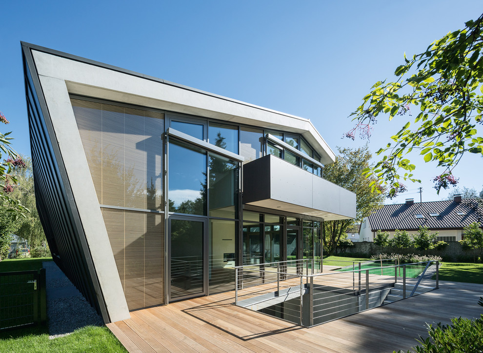 Свежая идея для дизайна: двухэтажный, серый, стеклянный частный загородный дом среднего размера в современном стиле с плоской крышей и металлической крышей - отличное фото интерьера
