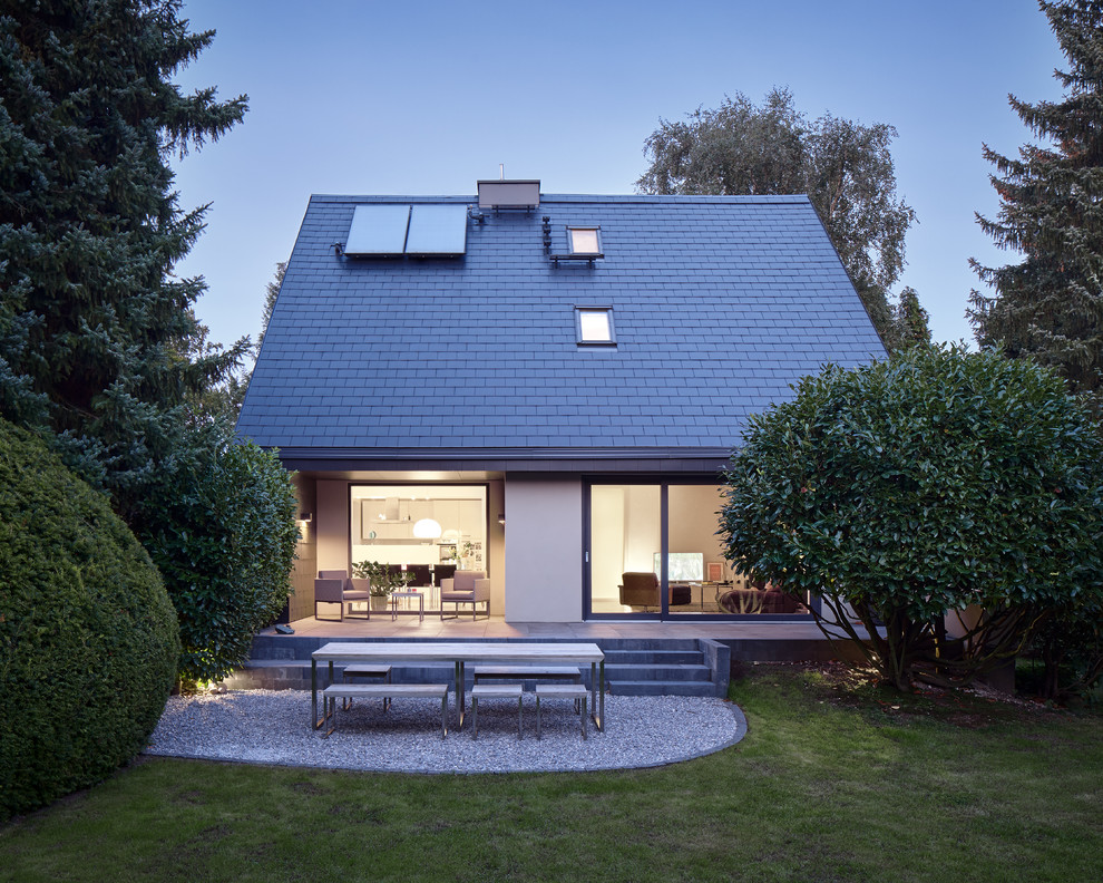 Exemple d'une façade de maison noire tendance en panneau de béton fibré avec un toit à deux pans.