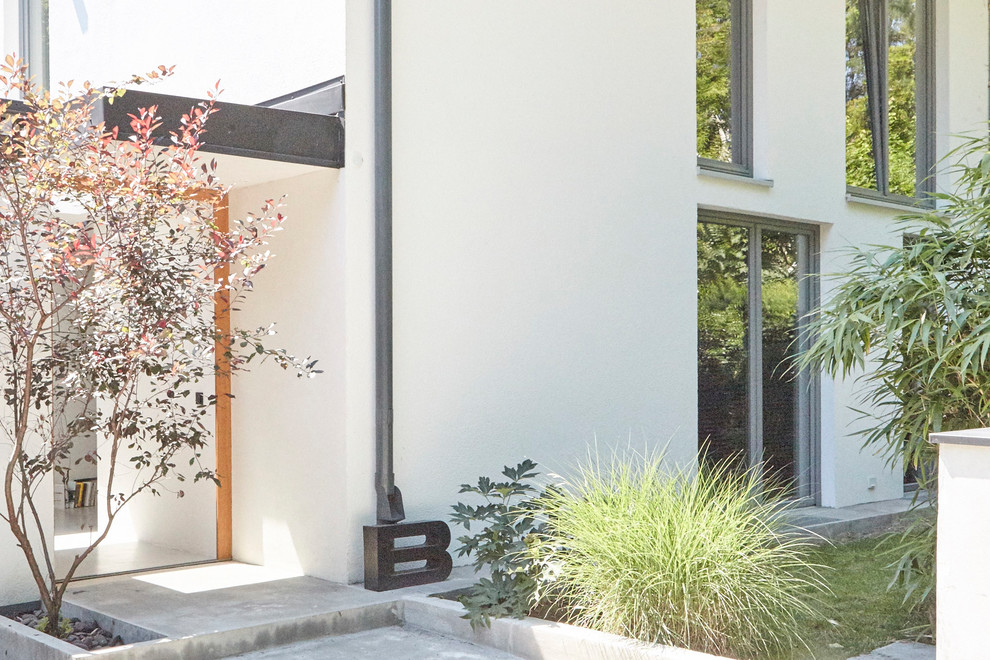 Ejemplo de fachada de casa bifamiliar blanca minimalista grande de dos plantas con revestimiento de estuco, tejado a dos aguas y tejado de teja de madera