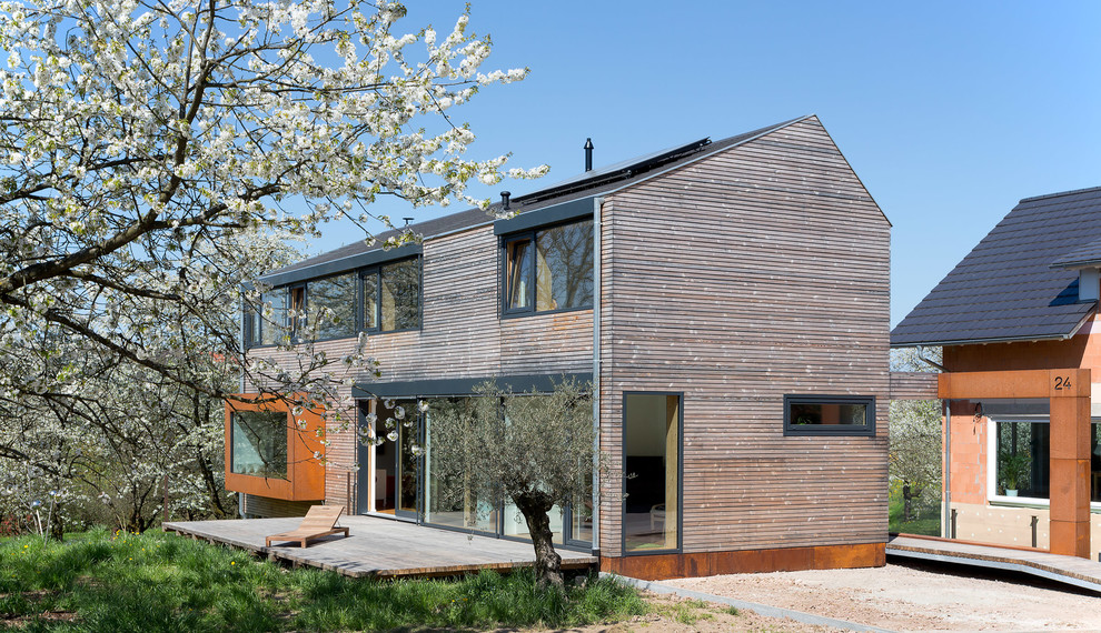 Ejemplo de fachada marrón actual de tamaño medio de dos plantas con revestimiento de madera y tejado a dos aguas