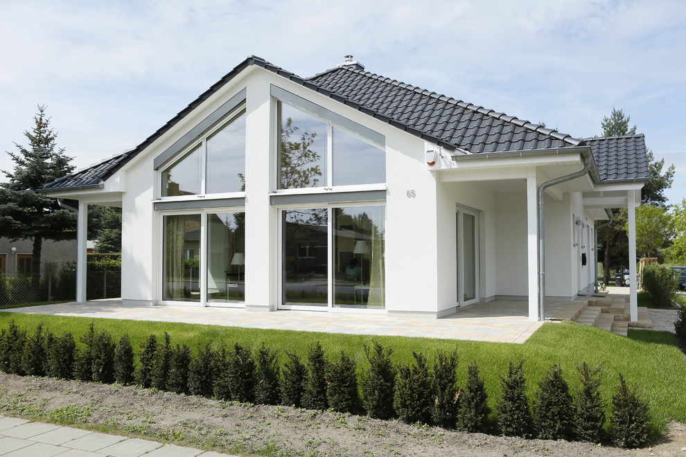 Inspiration pour une façade de maison blanche traditionnelle de plain-pied avec un toit à quatre pans.