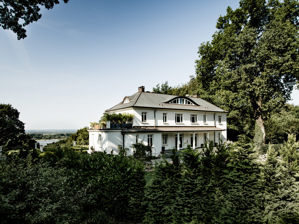На фото: большой, трехэтажный, белый дом в классическом стиле с мансардной крышей с