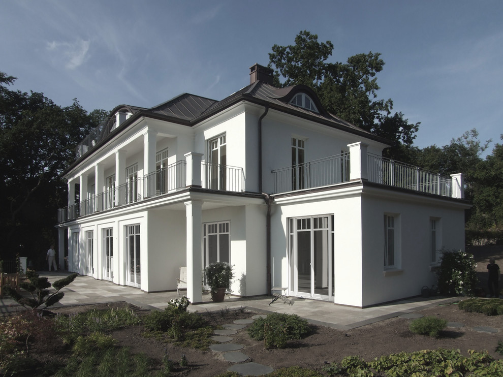 Immagine della facciata di una casa grande bianca classica a tre piani