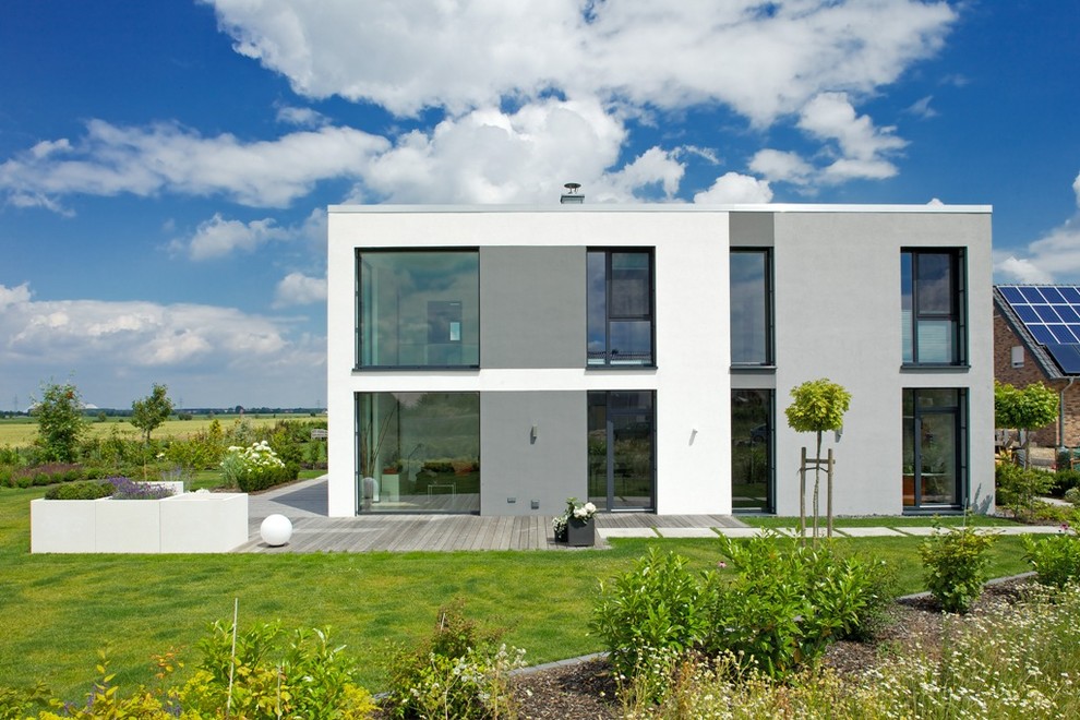 Inspiration for a medium sized and white modern two floor house exterior in Hanover with a flat roof.