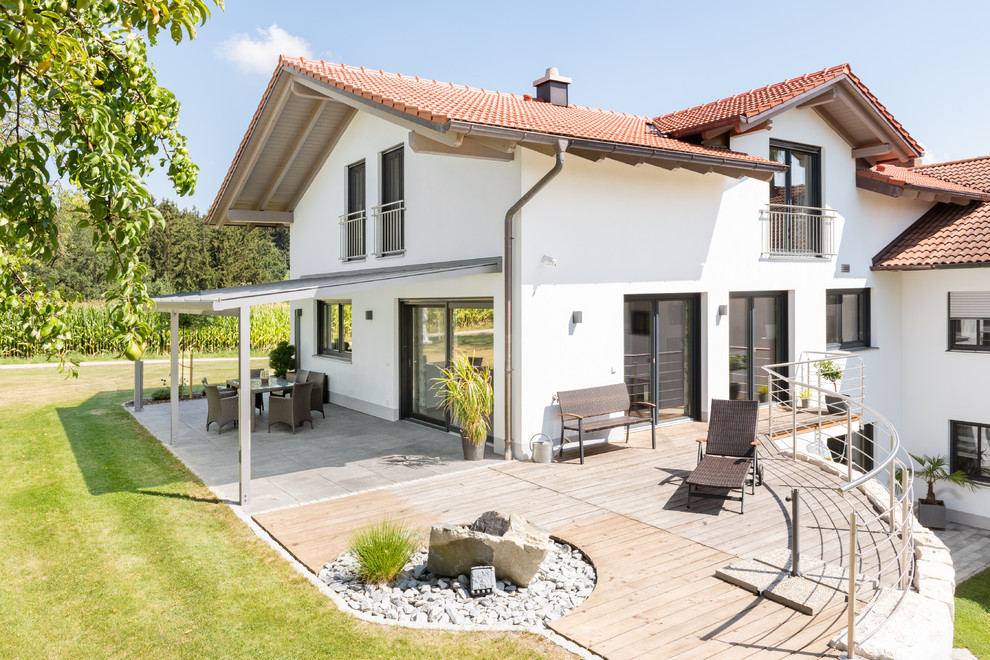 Inspiration for a large contemporary white two-story stucco exterior home remodel in Nuremberg with a tile roof