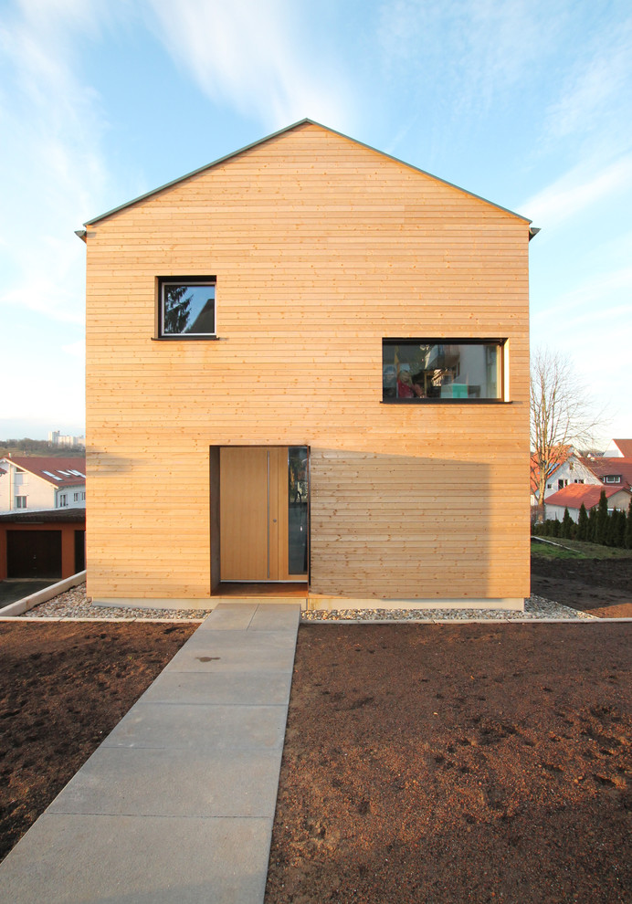 Modelo de fachada marrón actual de tamaño medio con revestimiento de madera y tejado a dos aguas