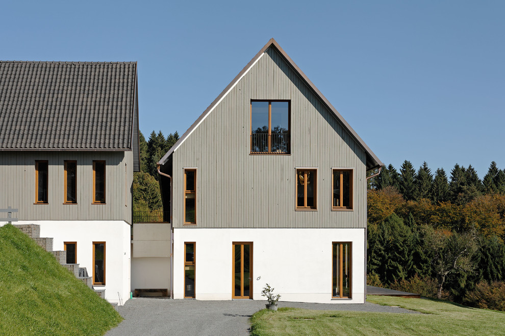 Идея дизайна: большой, трехэтажный, серый дом в стиле кантри с комбинированной облицовкой и двускатной крышей