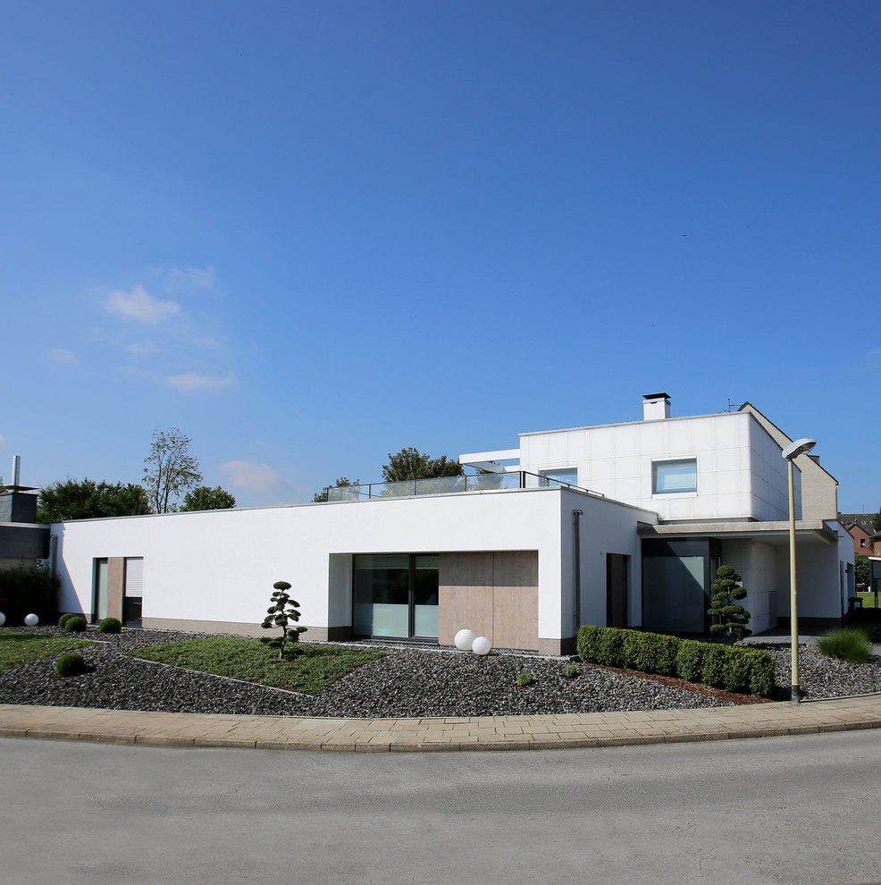 На фото: двухэтажный, белый дом среднего размера в стиле модернизм с плоской крышей