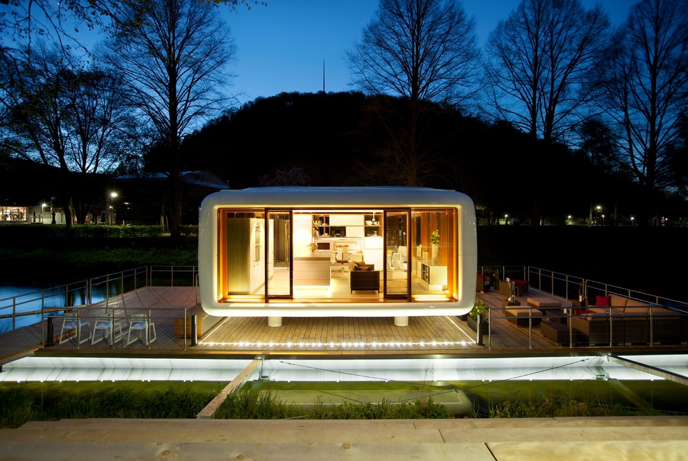 Свежая идея для дизайна: маленький, одноэтажный, стеклянный, белый многоквартирный дом в стиле модернизм с плоской крышей и крышей из смешанных материалов для на участке и в саду - отличное фото интерьера