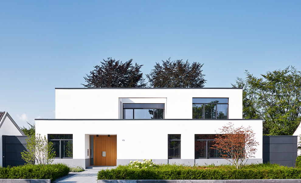 Zweistöckiges, Mittelgroßes Modernes Haus mit weißer Fassadenfarbe und Flachdach in Düsseldorf