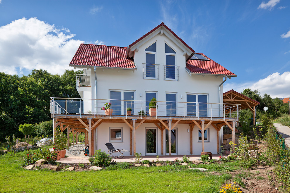Modelo de fachada de casa blanca clásica renovada de dos plantas con tejado de teja de barro y tejado a dos aguas