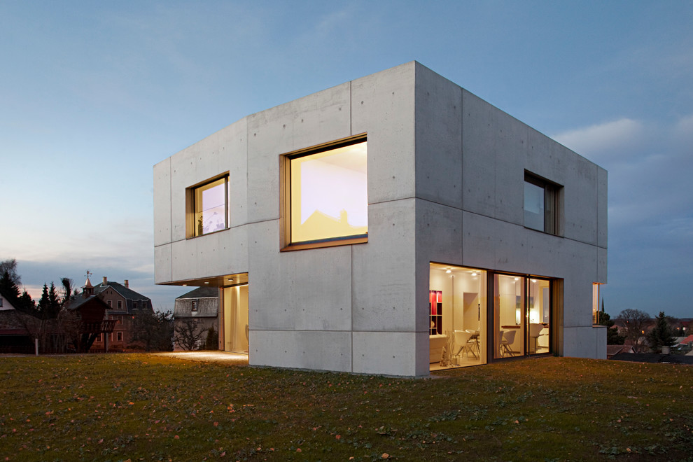 Gey and medium sized contemporary two floor concrete house exterior in Leipzig with a flat roof.