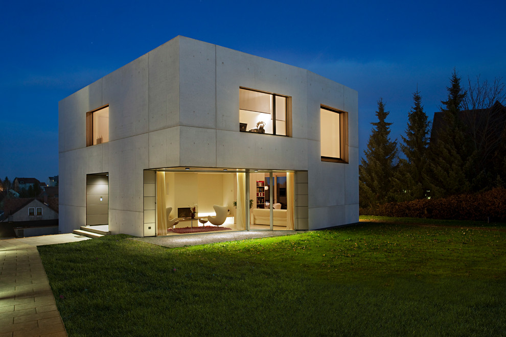 Gey contemporary two floor concrete house exterior in Leipzig with a flat roof.