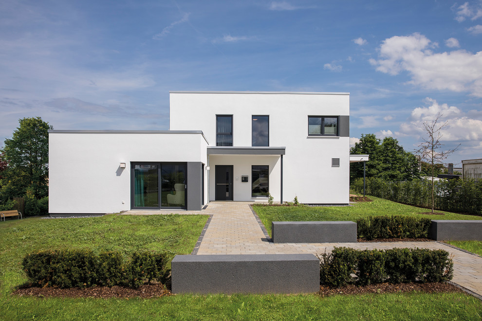 Diseño de fachada de casa bifamiliar blanca actual de tamaño medio de dos plantas con revestimiento de estuco y tejado plano