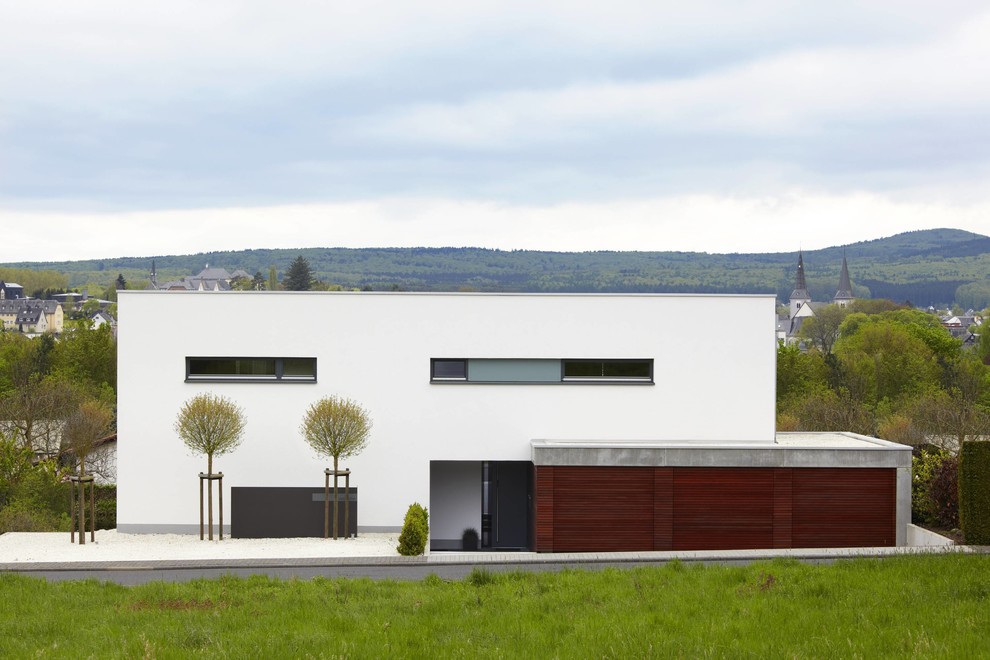 Источник вдохновения для домашнего уюта: двухэтажный, белый дом среднего размера в стиле модернизм с плоской крышей