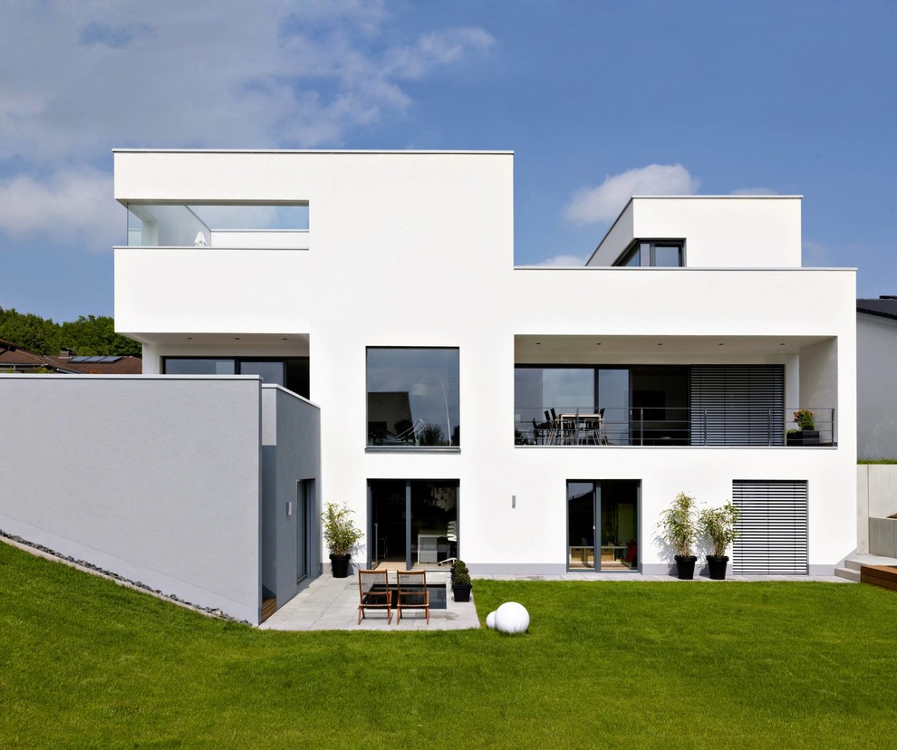 На фото: трехэтажный, белый дом среднего размера в стиле модернизм с плоской крышей с