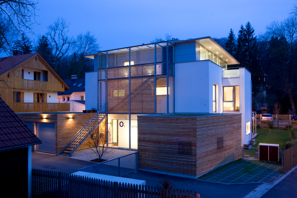 Dreistöckiges Modernes Wohnung mit Putzfassade, weißer Fassadenfarbe, Blechdach und Flachdach in München