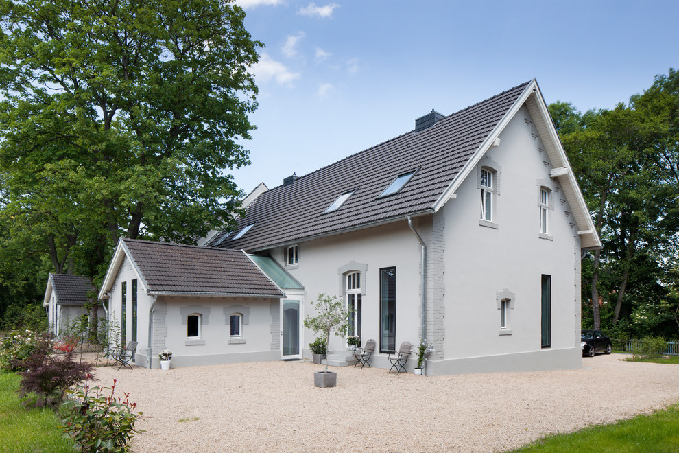 Inspiration pour une grande façade de maison grise nordique à un étage avec un toit à deux pans.